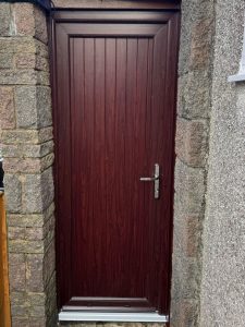 Replacement Rosewood uPVC door with vertical panels and chrome hardware